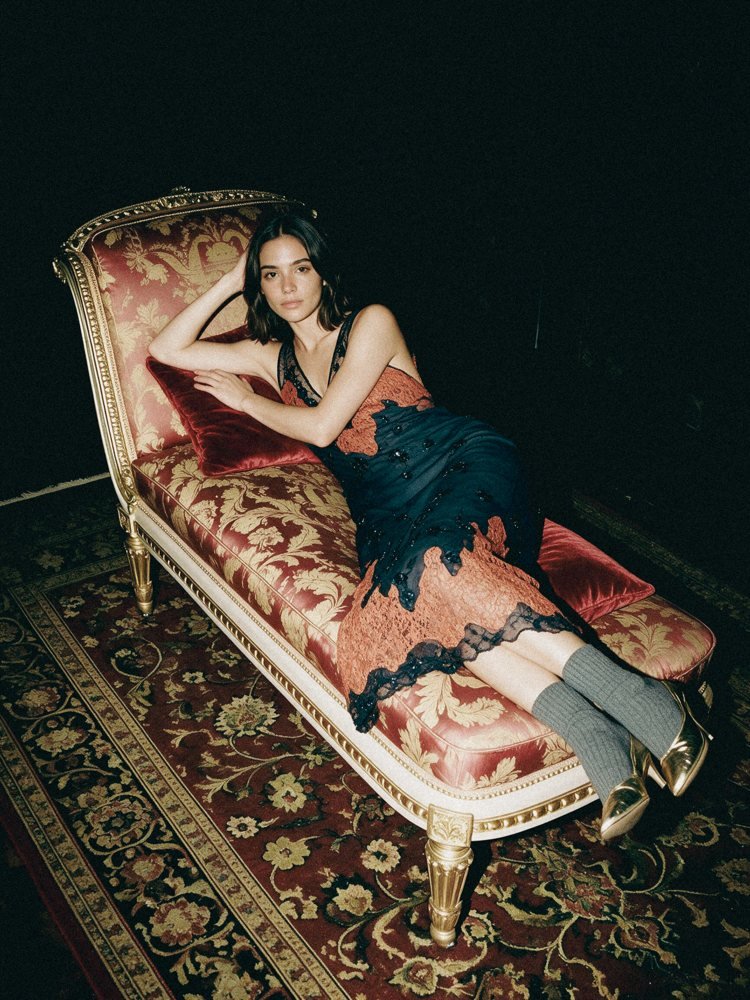 Joana com o mesmo vestido deitada num canapé de damasco vermelho