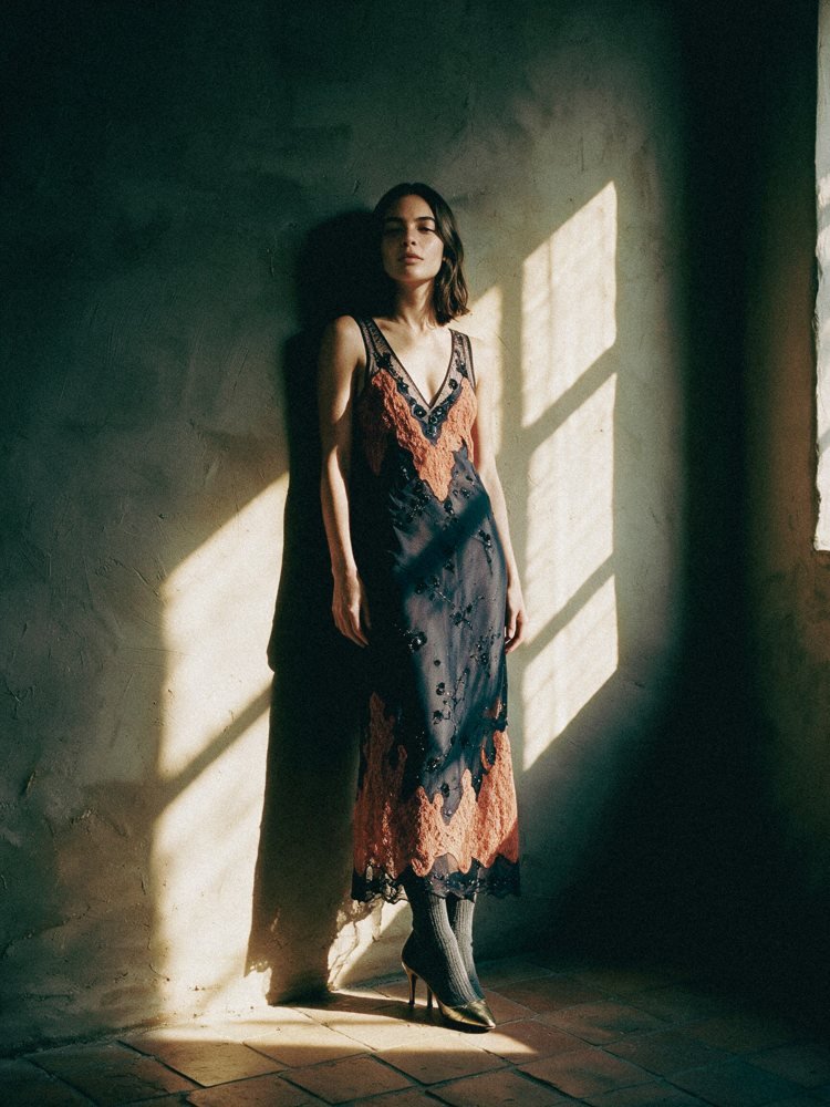 Joana com o vestido de tule encostada a uma parede com riscas de sol